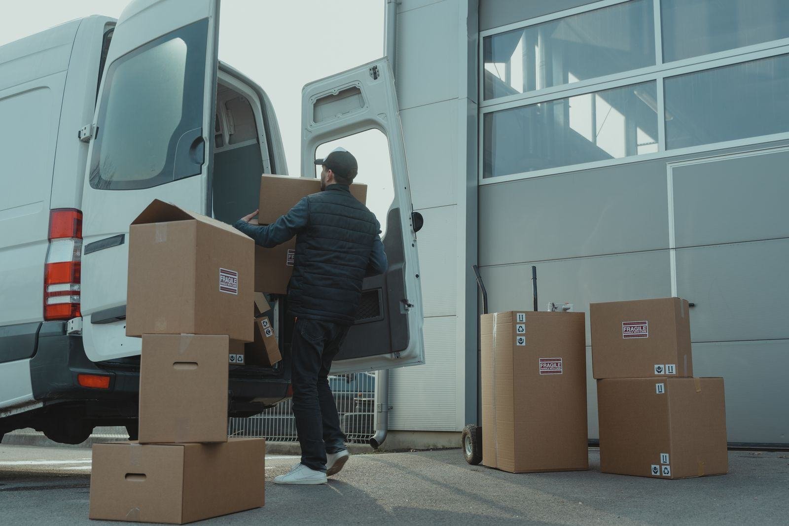 Courier loading boxes into a van