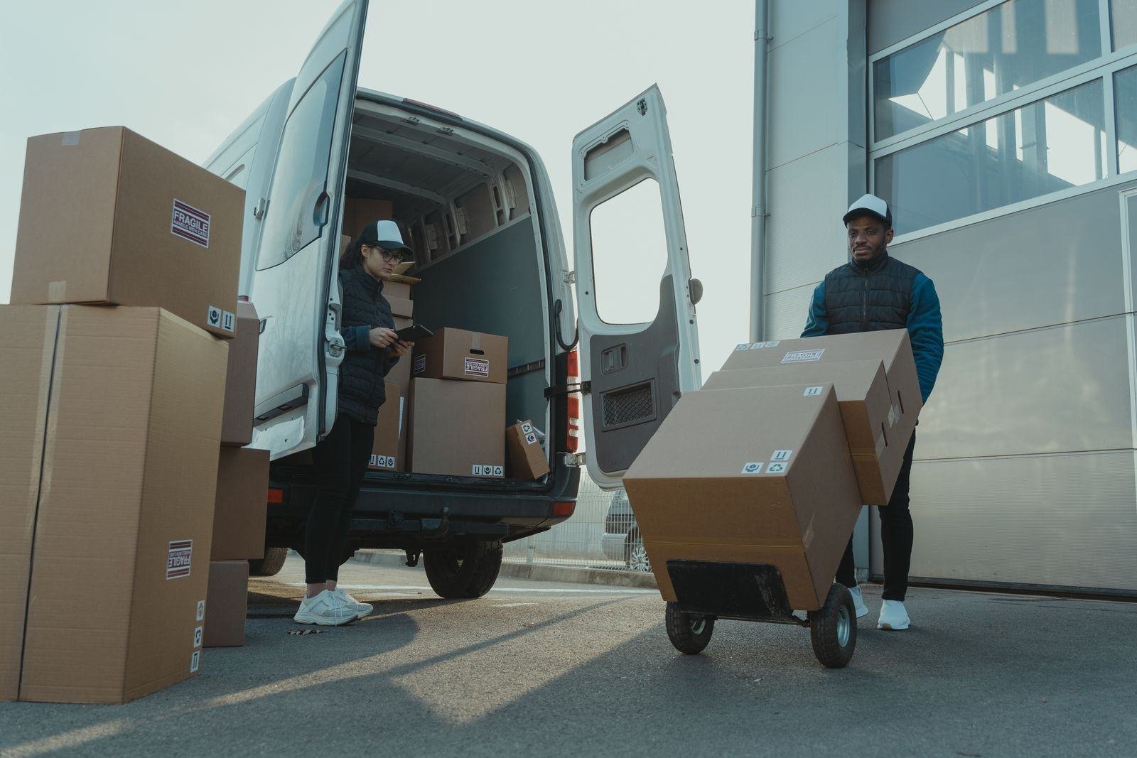 Couriers unloading parcels from a van