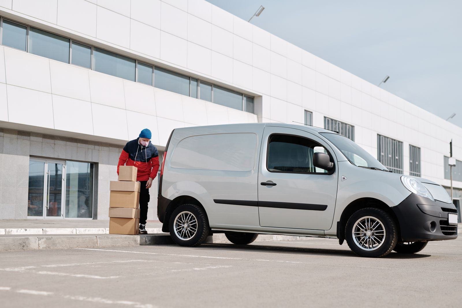 Courier loading parcels into a delivery van